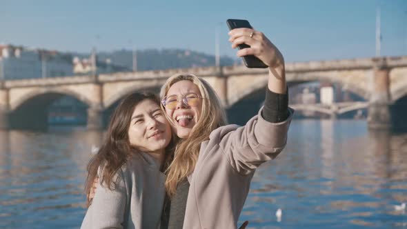 Positive Friends Walking Outside and Sharing Mood Using the Cellphone