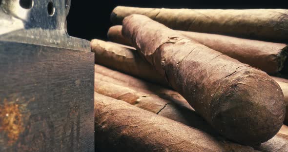 Cigars with lighter in humidor. View through a cigar cutter.