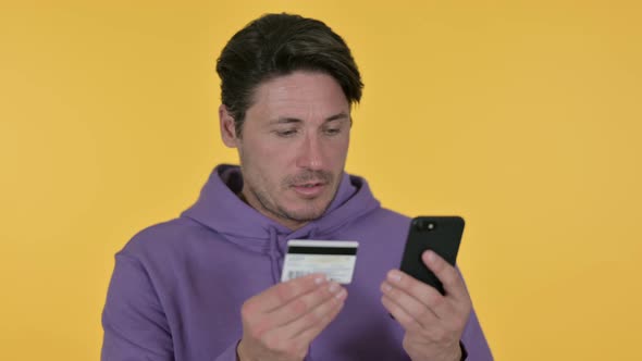 Online Shopping on Smartphone By Man, Yellow Background 