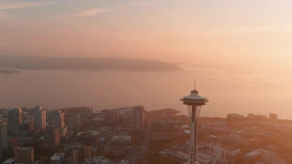 Wide aerial of the Space Needle during sunset with a layer of smoky haze over the Puget Sound.