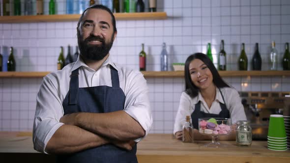 Positive Coffee Shop Employees in Aprons Smiling