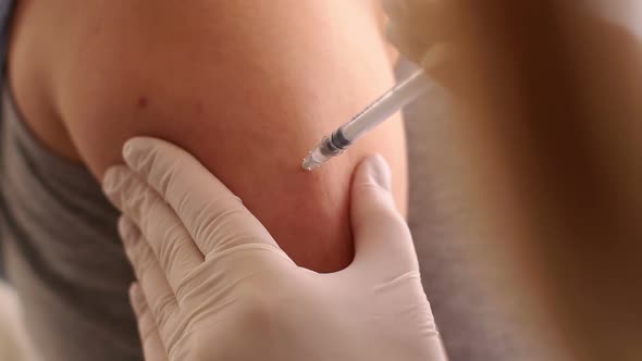 Doctor Makes Vaccination in the Shoulder of Patient in a Hospital