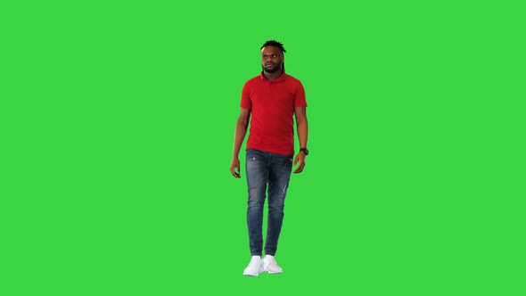 Young African American Man Walks and Takes a Look at His Watch on a Green Screen Chroma Key