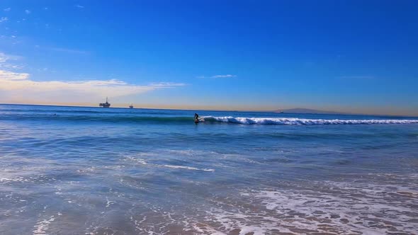 Guy paddle board surfing in Huntington Beach California