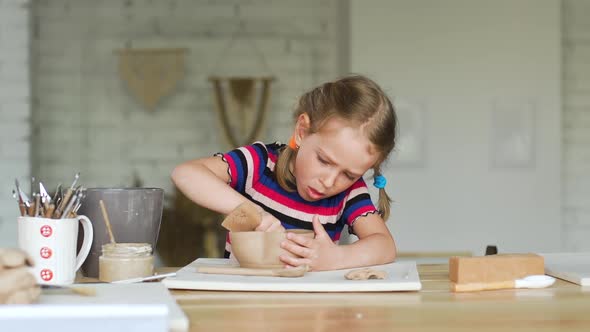 Little Girl Making a Pot in a Pottery Workshop