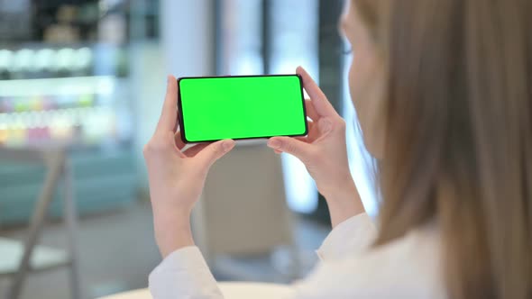 Woman Looking at Smartphone with Green Chroma Key Screen