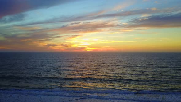 Aerial drone view of a sunset at the beach over the ocean