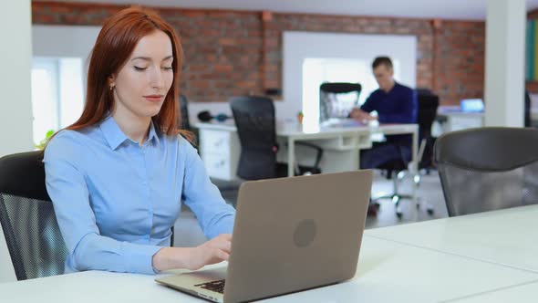 Businesswoman with Red Hair Posing Working on PC