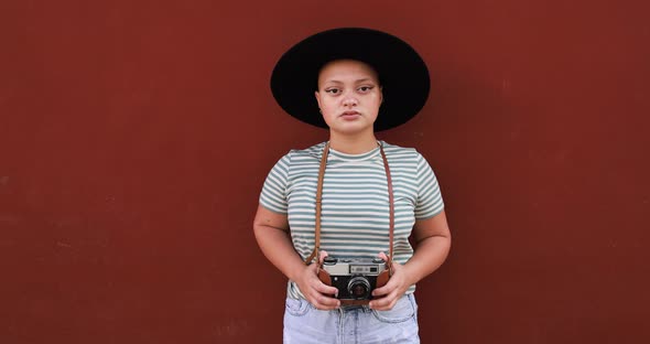 Bald young woman with vintage camera wearing trendy hat - Tavel, diversity and female power concept