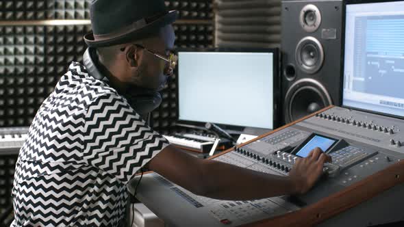 Sound Engineer Using Mixing Console at Recording Studio