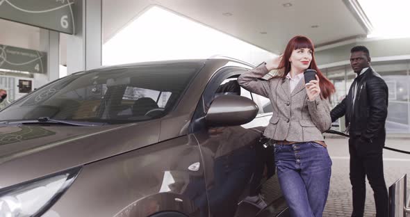 Front View of Pretty Redhaired Caucasian Woman Holding Take Away Coffee While