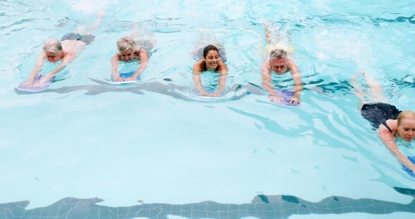 Swim trainer assisting seniors in swimming
