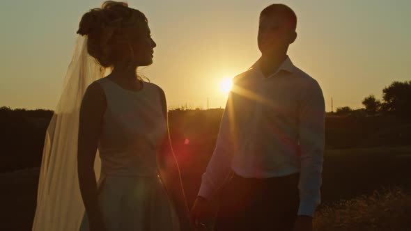 The Wedding Couple is Having Fun at Sunset on the Mountain Hills By the River