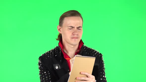 Guy Thinks and Writes with Pencil in Notebook. Green Screen