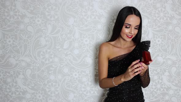 A young attractive woman wearing a black elegant dress with long brown hair