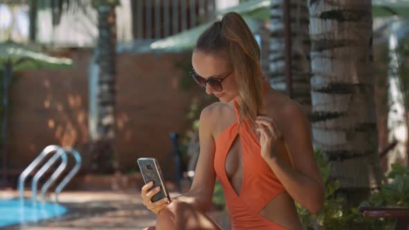 Girl Straightens Haircut Holds Phone By Home Pool