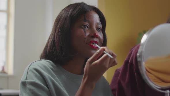 A Beautiful Lady is Drawing Halloween Makeup