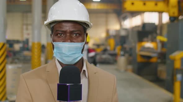 TV Reporter in Mask Talking in Mic in Factory