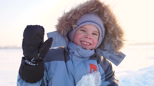 Happy Child with Fun Laughing in Winter Park on a Sunny Day