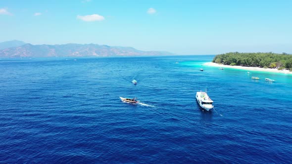 Aerial tourism of marine tourist beach journey by blue ocean and white sandy background of a picnic 