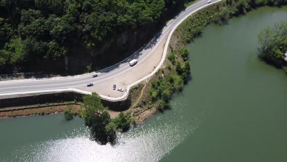 Horizontal aerial view of the lake, road and forest trees 4K