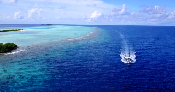 Daytime overhead copy space shot of a sunshine white sandy paradise beach and aqua blue water backgr