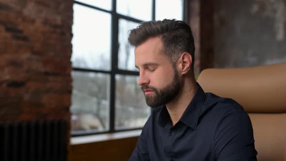 Excited Caucasian Man Sitting at the Table Looking at the Computer Screen and Rejoicing