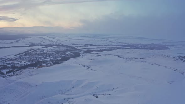 View of the Russian Village Through the Clouds in Winter at Dusk