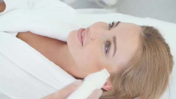 Woman Having a Stimulating Facial Treatment From a Therapist