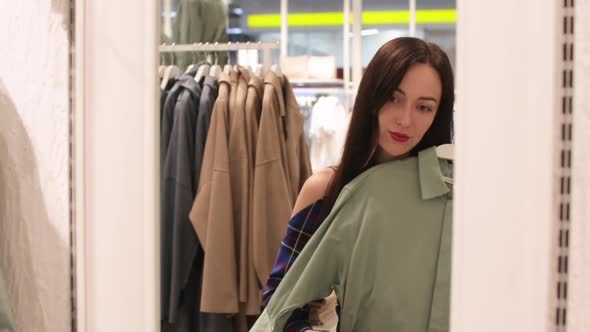 Young Woman Standing in Front of Mirror and Trying on Outfit in Shop