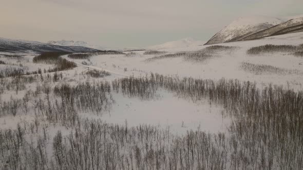 Snowscape Terrain And Isolated Road With Person Next To A Park Car In Oldervik, Norway. Aerial Drone