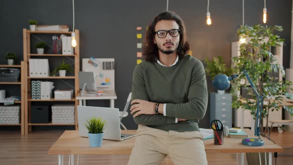 Portrait of Serious Young Businessman Looking at Camera Standing in Office in the Evening