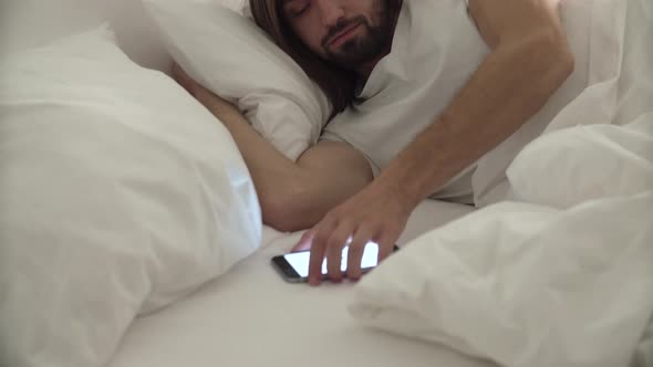 Wake Up. Man Sleeping In Bed With Phone Alarm