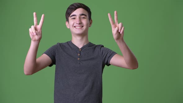 Young Handsome Iranian Teenage Boy Against Green Background