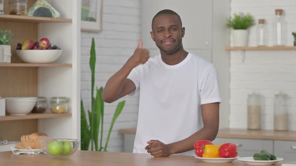 Sporty African Man Showing Thumbs Up While Standing in Kitchen