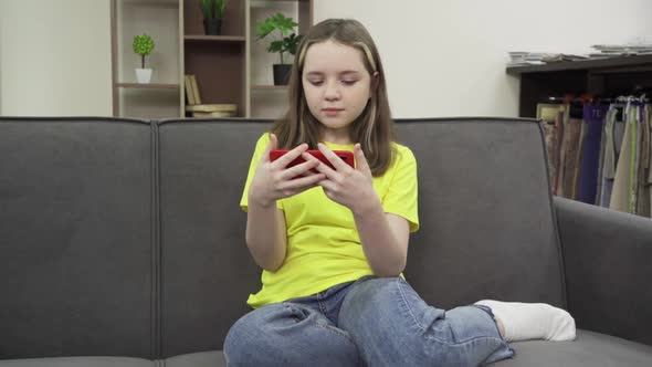 Happy Teen Girl Holding Cell Phone Using Smartphone Device at Home