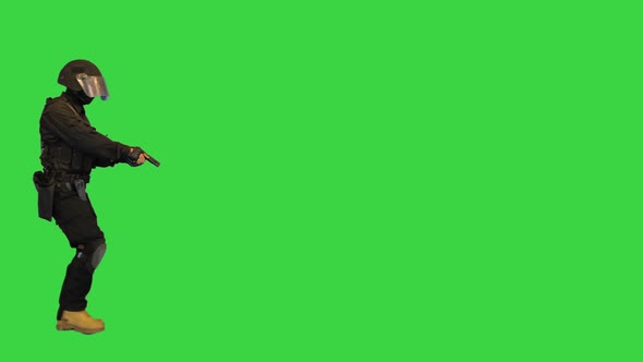 Police SWAT Armed Fighter Walking with a Hand Gun on a Green Screen Chroma Key