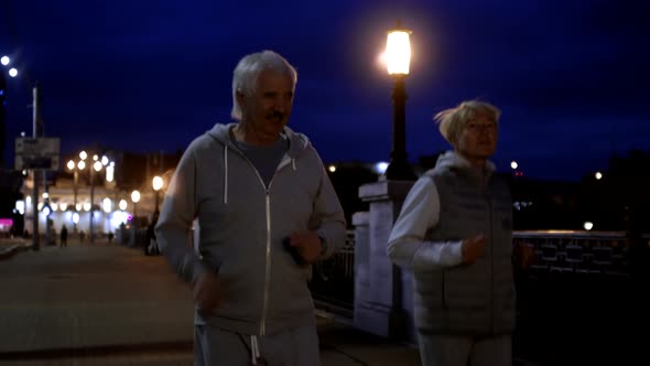 Senior People Jogging Outdoors in Evening