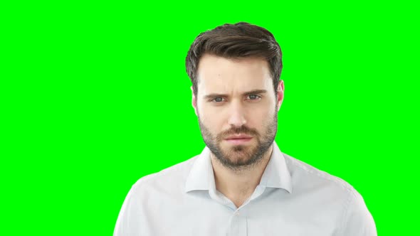 Worried man standing against green screen