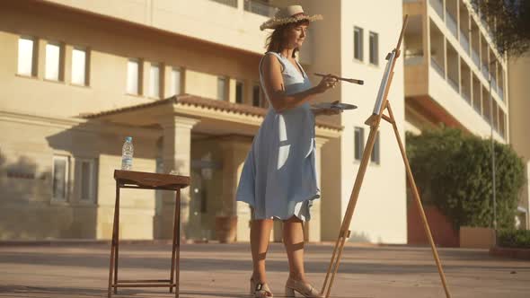 Wide Shot of Talented Confident Woman Painting in Sunlight Outdoors and Leaving