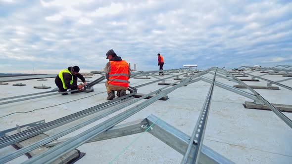 Workers installing solar panels outdoors. Male technician installing photovoltaic solar panels