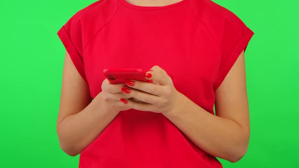 Woman in Red Tshirt Texting on Her Smartphone on Green Screen Chroma Key Background