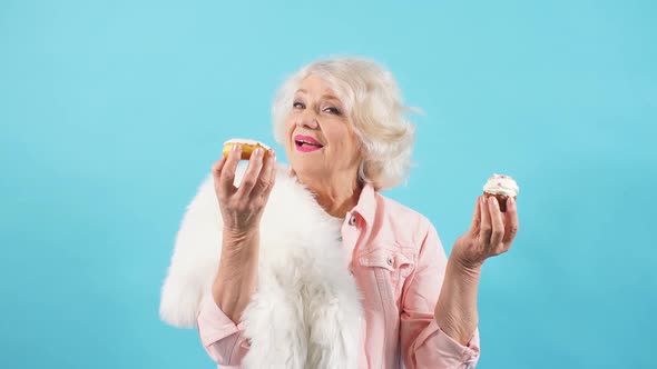 Senior Happy Cheerful Woman Holding Cake Muffins in Hands