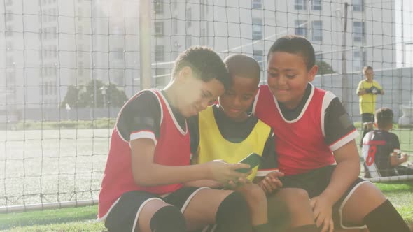 Soccer kids in red taking a selfie and laughing in a sunny day