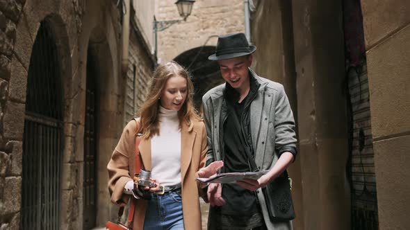 Beautiful and Style Friends Walking with Map and Camera Through Tight Street