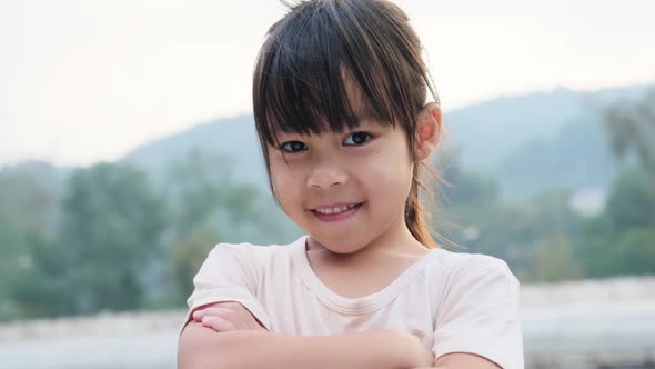 Portrait of a cute Asian preschooler smiling happily in the summer garden.