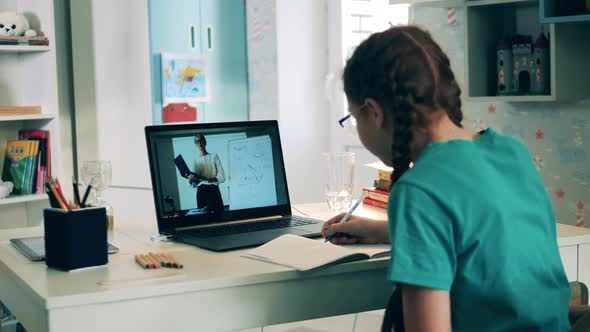 Schoolgirl Studying Remotely at Home Using a Laptop. Remote Education Caused By the Covid-19