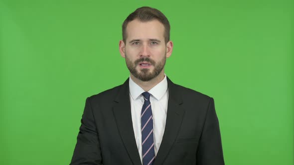 Young Businessman Putting His Finger on Lips Against Chroma Key