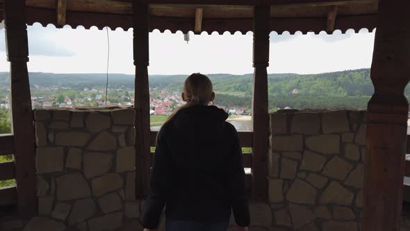 Attractive Female Traveller Using Binoculars for Looking Around Valley Near the Old Castle