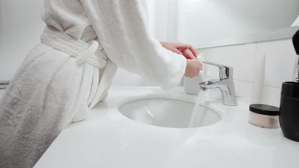 Woman Washing Hands with Antibacterial Soap at Home